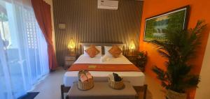 a hotel room with a bed with two shoes on it at lala-Oh Resort in Lalao +28 photos