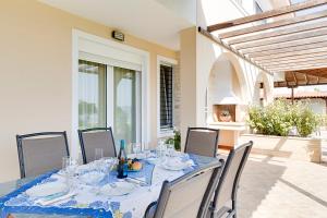 a dining table with a blue table cloth and chairs at Villa Nefeli Akti Salonikiou B in Ayios Nikolaos Sithonia