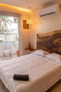 a bedroom with a large white bed with a window at Japandi Las Islas in Puntarenas