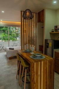 a kitchen with a wooden table with two plates on it at Japandi Las Islas in Puntarenas