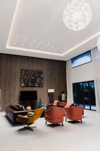 a living room with couches and chairs and a fireplace at Hôtel Touraco in Assinie