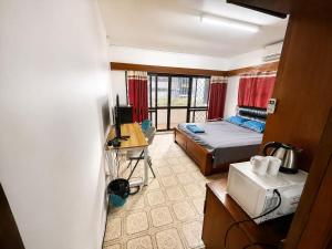 a room with a bed and a microwave in it at King Room with Private Bathroom and Free WiFI in SUVA CBD in The Domain +4 photos