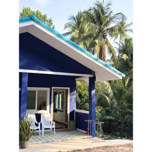 a blue house with two chairs and a table at Blue House Klong Hin in Ko Kood
