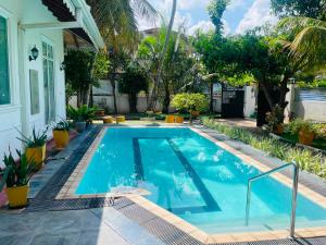 a swimming pool in front of a house at The Negombo Manor Villa in Negombo