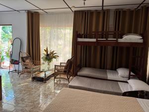 a bedroom with two bunk beds and a living room at Deep Forest Garden Hotel in Puerto Princesa City