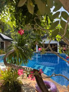 a pool at the resort with flowers and trees at Deep Forest Garden Hotel in Puerto Princesa City +34 photos