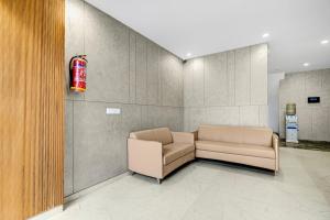 a waiting room with a couch and a fire extinguisher at Townhouse Sector 51 Gurgaon in Gurgaon