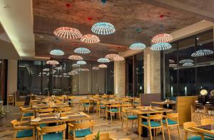 a restaurant with tables and chairs and umbrellas at Soaltee Westend Lakeside Pokhara in Pokhara