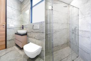 a bathroom with a toilet and a glass shower at Townhouse Sector 51 Gurgaon in Gurgaon