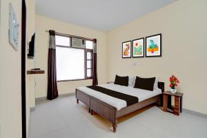 a bedroom with a bed and a window at Hotel O Chandigarh Outer Ring Road Formerly Ganesha in Chandīgarh