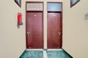 two red doors in a room with a fire extinguisher at Hotel O Chandigarh Outer Ring Road Formerly Ganesha in Chandīgarh