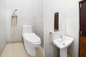 a white bathroom with a toilet and a sink at Hotel O Chandigarh Outer Ring Road Formerly Ganesha in Chandīgarh