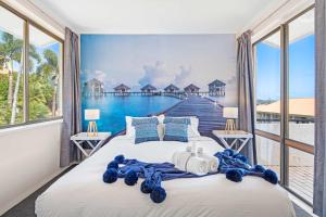 a bedroom with a large window with a view of the ocean at Ocean View Apartment 27 KIDS STAY FREE in Airlie Beach