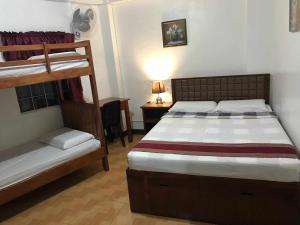 a bedroom with two bunk beds and a desk at The Verandah Lodge Bed and breakfast in Banaue