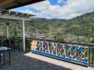 a bench on a balcony with a view of a mountain at The Verandah Lodge Bed and breakfast in Banaue