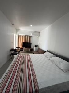 a bedroom with a bed and a couch and a table at Malima Stay in Suva