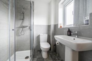 a bathroom with a toilet and a sink and a shower at Bright 4 Bedroom Home in Walsall, Free Parking and for EVs in Walsall