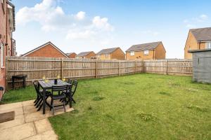 a backyard with a table and chairs and a fence at Bright 4 Bedroom Home in Walsall, Free Parking and for EVs in Walsall