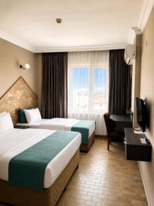 a hotel room with two beds and a television at Grand Park Hotel Corlu City Center Bed and Breakfast in Çorlu +101 photos