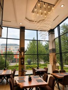 a restaurant with tables and chairs and a chandelier at Grand Park Hotel Corlu City Center Bed and Breakfast in Çorlu