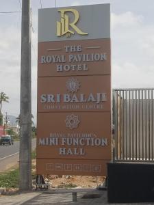 a sign for the royal pavilion hotel next to a gate at The Royal Pavilion Hotel in Kanipakam
