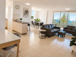 a living room with a couch and a table at Tradewinds Apartments in Coffs Harbour