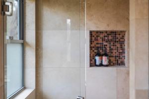 a shower with a glass door with two bottles at Clayfields Hunter Valley in Pokolbin +29 photos
