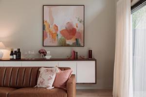 a living room with a couch and a picture on the wall at Clayfields Hunter Valley in Pokolbin