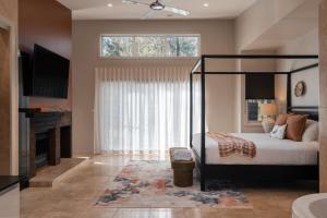 a bedroom with a canopy bed and a large window at Clayfields Hunter Valley in Pokolbin