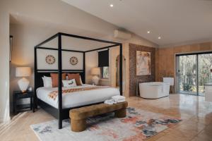 a bedroom with a black canopy bed and a tub at Clayfields Hunter Valley in Pokolbin