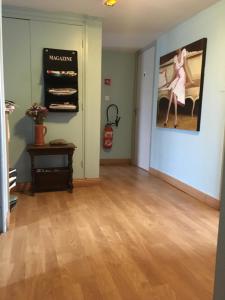 a living room with a painting of a woman on the wall at Le Ptit Ecureuil in Tosse