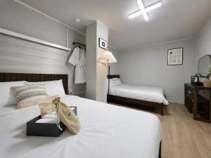 a bedroom with a white bed with a purse on it at 페블스테이 남포점 in Busan +53 photos