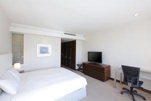 a bedroom with a bed and a desk and a television at Geoje Samsung Hotel in Geoje