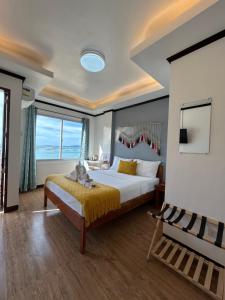 a bedroom with a large bed and a large window at Morocco Hotel El Nido in El Nido