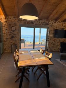 a dining room with a table and a view of the ocean at Stone Villa, Infinity Pool & Libyan Sea Views in Agia Galini