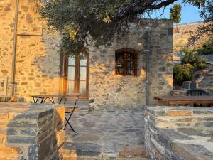 a stone building with benches and a window at Stone Villa, Infinity Pool & Libyan Sea Views in Agia Galini