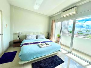 a bedroom with a bed and a large window at Brianna Balcony Apartment in Ban Ton Chok