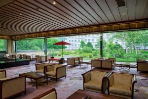 a restaurant with tables and chairs and a large window at Choyo Tei in Kamikawa