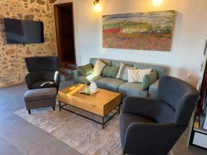 a living room with a couch and two chairs and a table at Stone Villa, Infinity Pool & Libyan Sea Views in Agia Galini