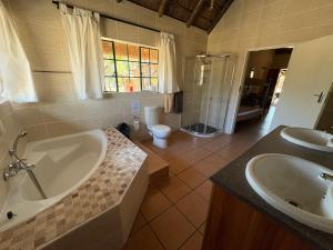 a bathroom with a tub and a sink and a toilet at Roaring Sky Base Camp in Cullinan +120 photos