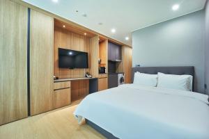 a bedroom with a bed and a flat screen tv at Jeonju Signature Hotel in Jeonju