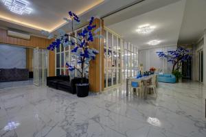 a lobby with a table and chairs and blue flowers at Hotel Bunga-Bunga By ARBA in Jakarta +54 photos