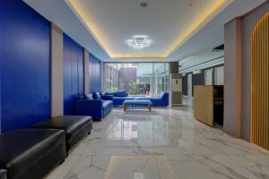 a living room with blue couches and a table at Hotel Bunga-Bunga By ARBA in Jakarta