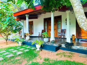 a house with potted plants in front of it at Sigiri Grand Villa in Sigiriya