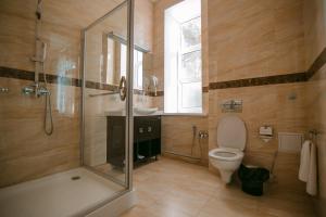 a bathroom with a shower and a toilet and a sink at Hotel Inju in Taraz