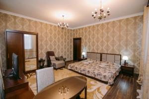 1 dormitorio con 1 cama y sala de estar en Hotel Inju, en Taraz