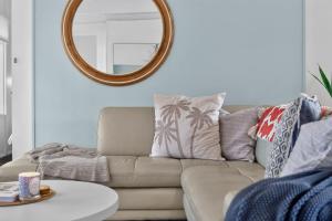 a living room with a couch and a mirror at River & Tide escape - On Galpin in Goolwa South