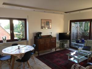 een woonkamer met een tafel en een televisie bij Haus 23 in Korschenbroich
