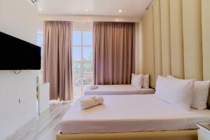 a hotel room with two beds and a television at Pitstop Mango Grove Retreat in Guimaras