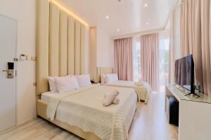 a hotel room with two beds and a television at Pitstop Mango Grove Retreat in Guimaras